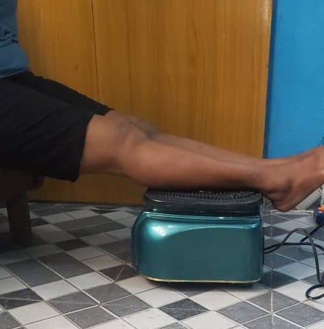 Close-up demonstration of feet placed on the blood circulation machine during a wellness session
