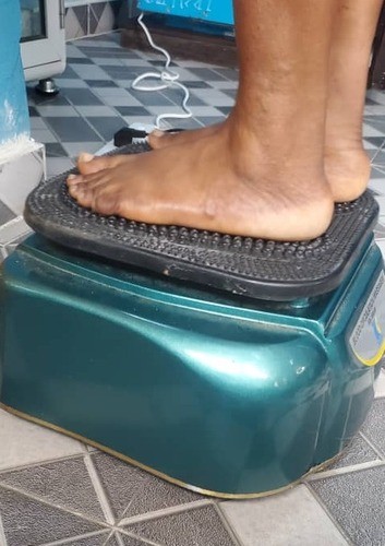 Member standing with both feet on a blood circulation machine during a wellness session in Ikeja, Lagos
